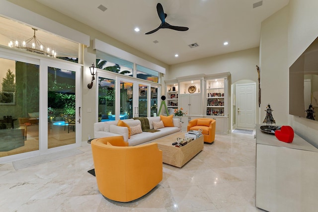 living room featuring french doors and ceiling fan with notable chandelier