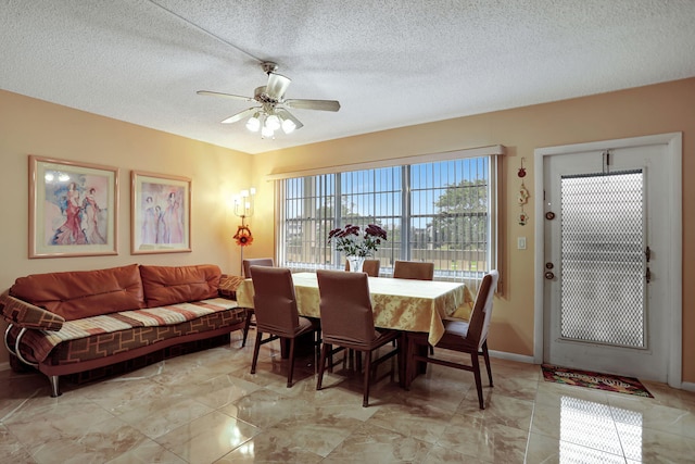 dining area with ceiling fan and a textured ceiling