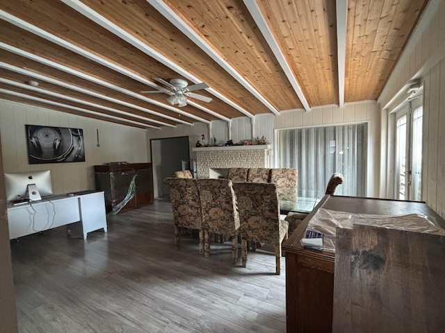 dining area with wood walls, french doors, dark hardwood / wood-style flooring, ceiling fan, and beamed ceiling