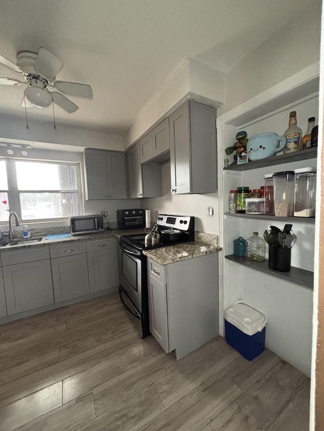 kitchen featuring gray cabinetry, appliances with stainless steel finishes, sink, light wood-type flooring, and ceiling fan