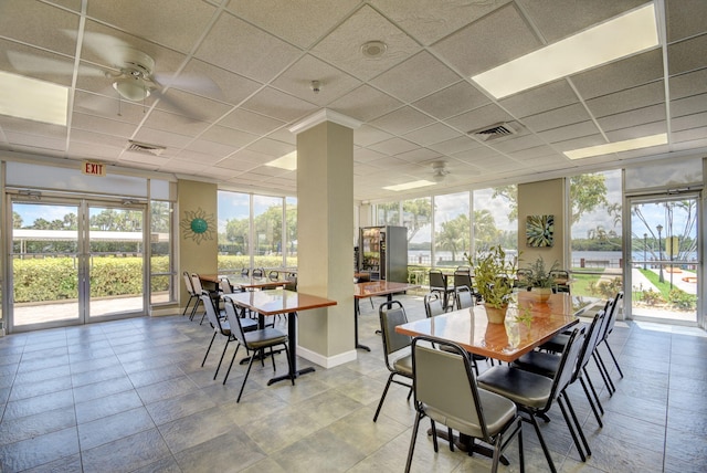 dining space with a drop ceiling and ceiling fan