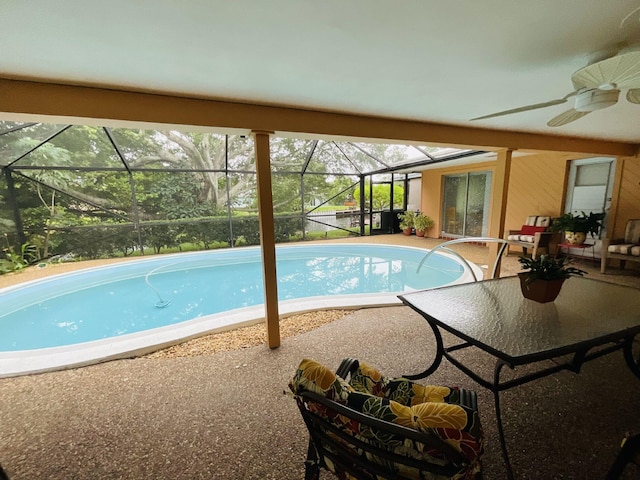 view of pool with ceiling fan, a lanai, and a patio