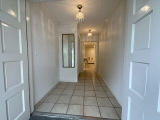 hall featuring light tile patterned flooring, a chandelier, and ornamental molding