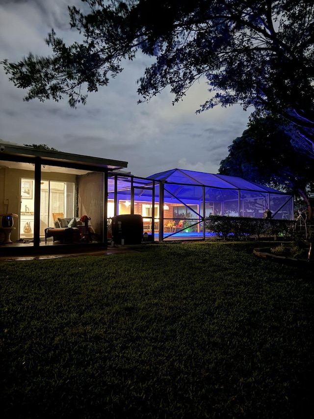 yard at dusk featuring a lanai