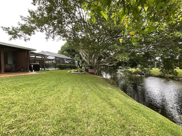 view of yard with a water view and a lanai