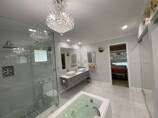 bathroom featuring tile patterned flooring, vanity, a shower with door, and a chandelier