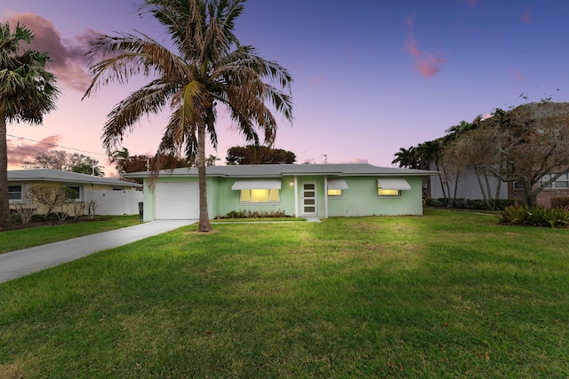 ranch-style house with a garage and a lawn