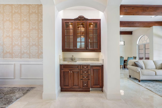 bar featuring sink, beamed ceiling, and light tile patterned floors