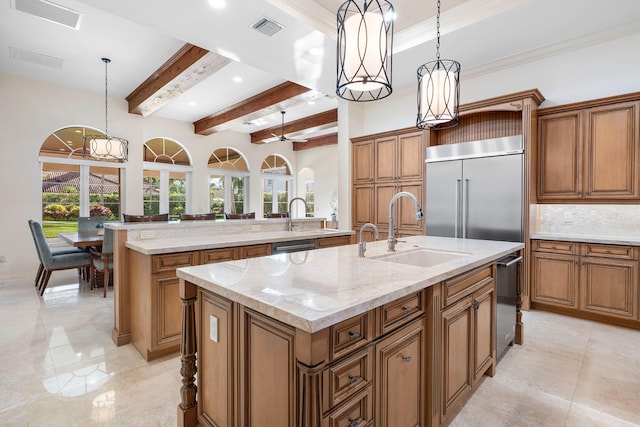 kitchen with a center island with sink, decorative light fixtures, stainless steel built in refrigerator, and sink