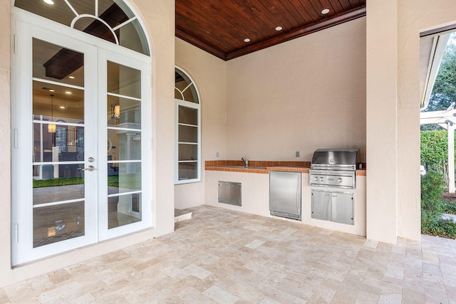 view of patio featuring french doors, sink, grilling area, and exterior kitchen