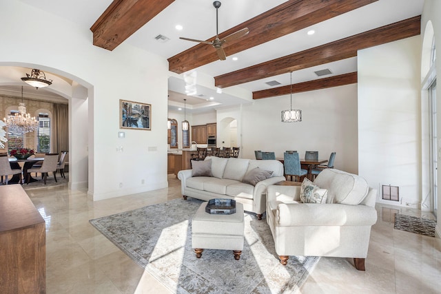 living room with ceiling fan with notable chandelier and beam ceiling