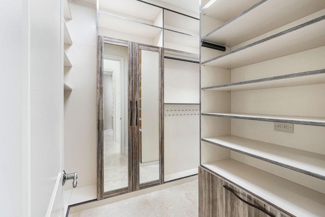 walk in closet with light tile patterned floors