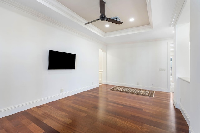 unfurnished room with dark hardwood / wood-style floors, a raised ceiling, ceiling fan, and ornamental molding