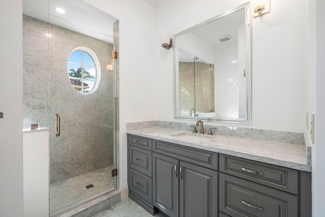 bathroom with vanity and a shower with door