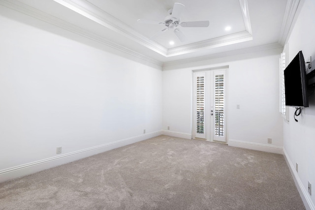 unfurnished bedroom featuring light carpet, a raised ceiling, ceiling fan, and ornamental molding