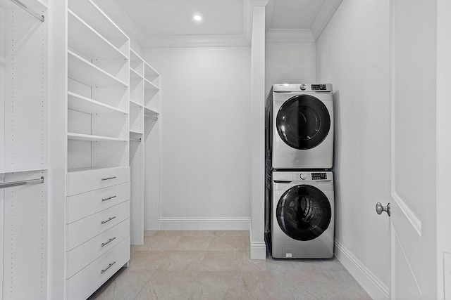 washroom with crown molding and stacked washer and dryer