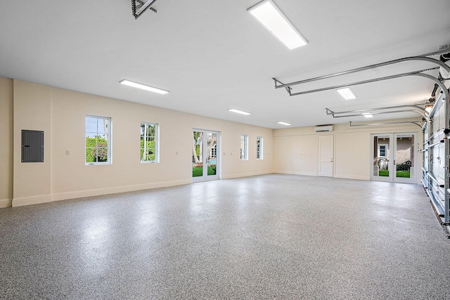 garage featuring french doors, electric panel, and a wall mounted AC