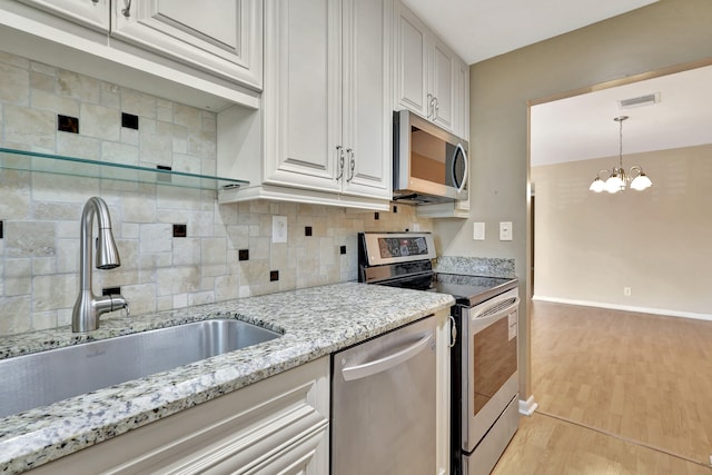 kitchen featuring white cabinetry, light hardwood / wood-style floors, appliances with stainless steel finishes, and sink