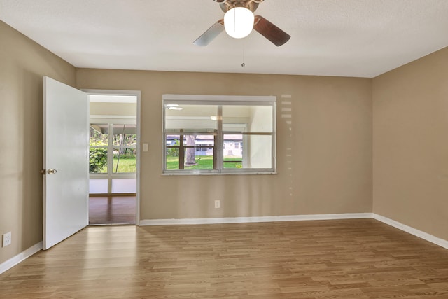 unfurnished room with ceiling fan, wood-type flooring, and a textured ceiling