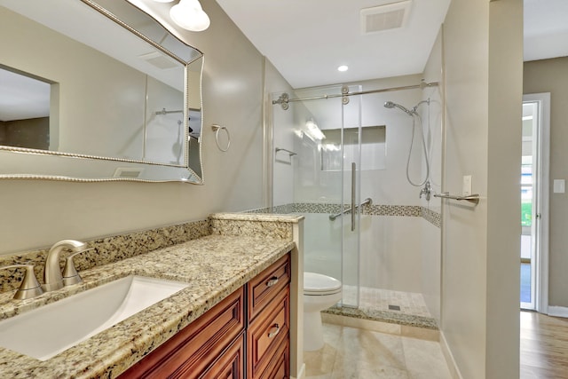 bathroom with vanity, walk in shower, toilet, and wood-type flooring