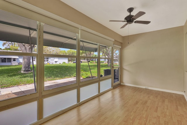 unfurnished sunroom featuring a healthy amount of sunlight and ceiling fan