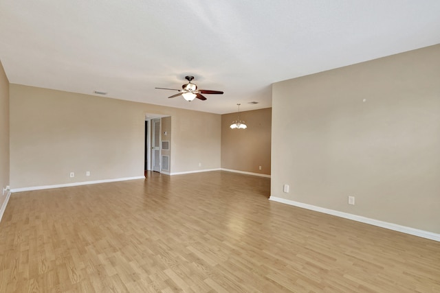 unfurnished room with light hardwood / wood-style flooring and ceiling fan with notable chandelier