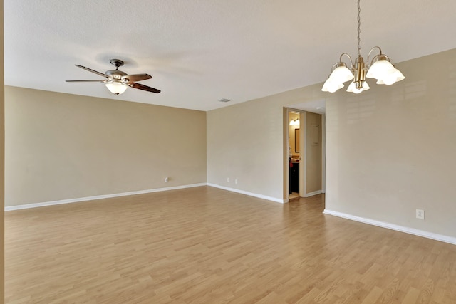 unfurnished room with a textured ceiling, light hardwood / wood-style flooring, and ceiling fan with notable chandelier