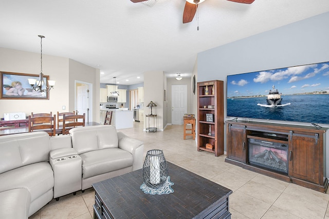 living room featuring light tile patterned floors and ceiling fan with notable chandelier