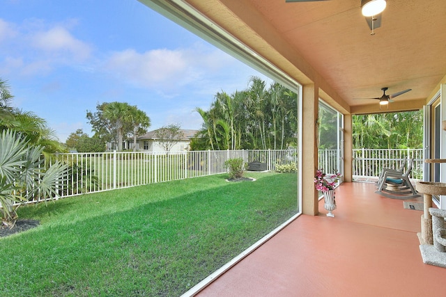 unfurnished sunroom featuring ceiling fan