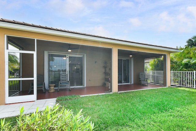 rear view of property with a patio, a yard, and a sunroom