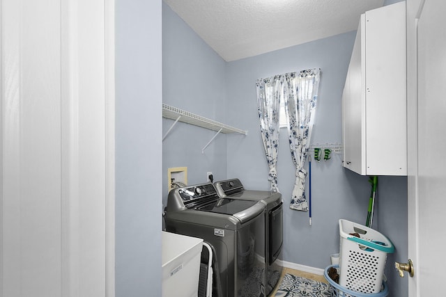 laundry area featuring a textured ceiling and washer and clothes dryer