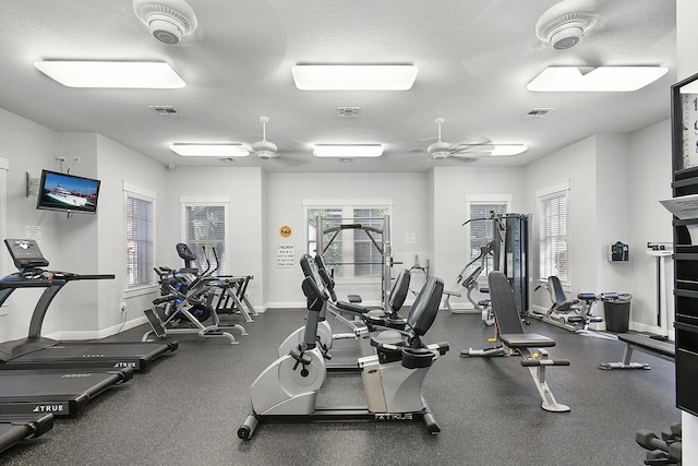 exercise room featuring a textured ceiling and ceiling fan