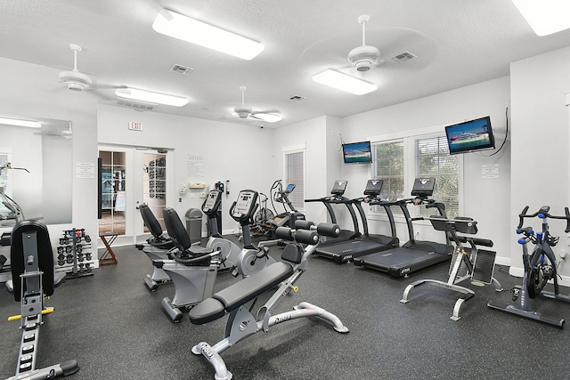 workout area featuring a textured ceiling and ceiling fan