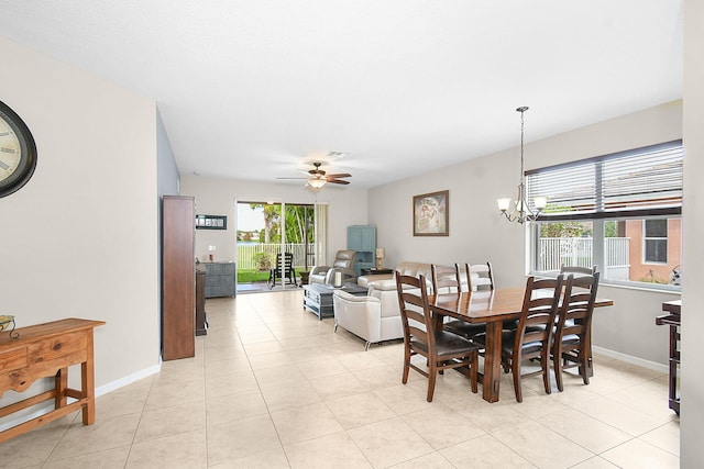 tiled dining space with ceiling fan with notable chandelier