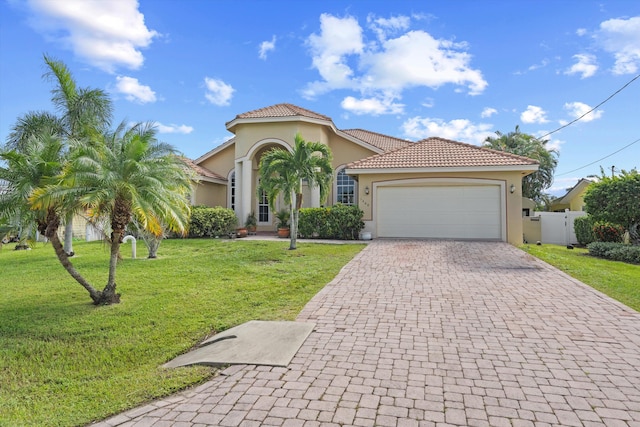 mediterranean / spanish home with a front lawn and a garage