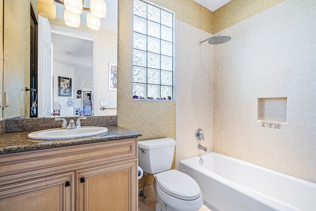 full bathroom featuring toilet, tiled shower / bath combo, and vanity