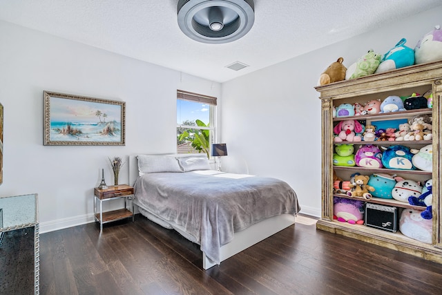 bedroom featuring a textured ceiling and dark hardwood / wood-style floors