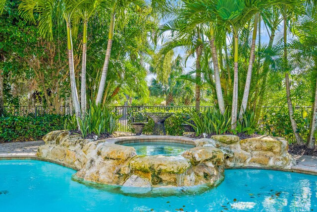 view of swimming pool featuring an in ground hot tub