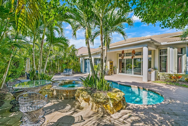 view of swimming pool with an in ground hot tub, a patio area, and ceiling fan