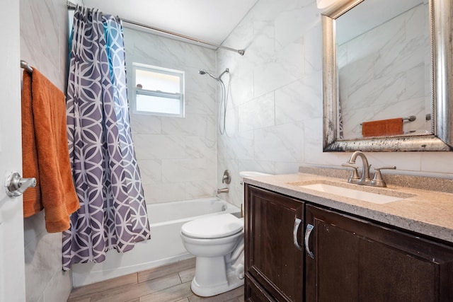 full bathroom featuring hardwood / wood-style floors, vanity, toilet, tile walls, and shower / tub combo with curtain