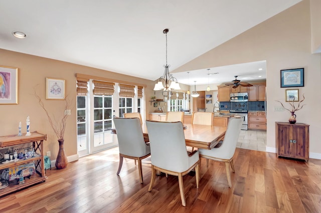 dining space featuring lofted ceiling, french doors, ceiling fan with notable chandelier, and light wood-type flooring