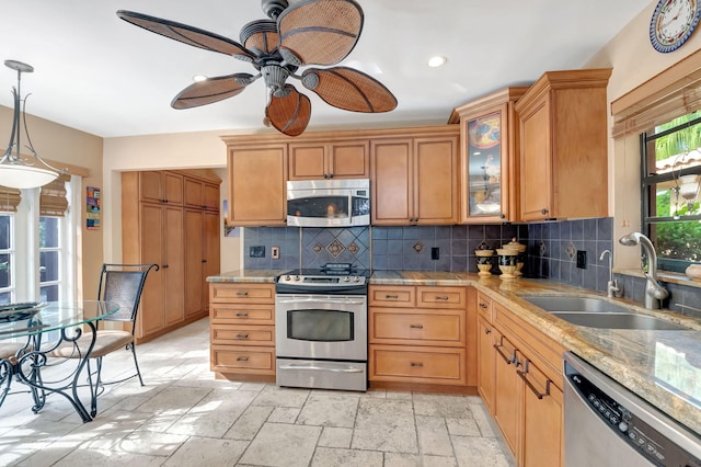 kitchen featuring decorative backsplash, ceiling fan, sink, decorative light fixtures, and stainless steel appliances