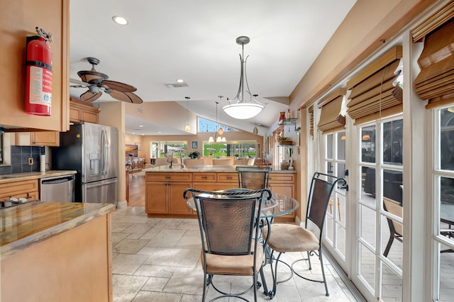 kitchen featuring appliances with stainless steel finishes, kitchen peninsula, ceiling fan, decorative light fixtures, and decorative backsplash