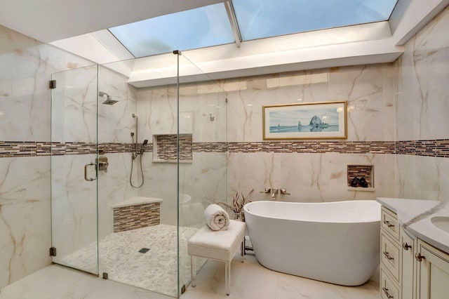 bathroom with tile walls, vanity, and independent shower and bath