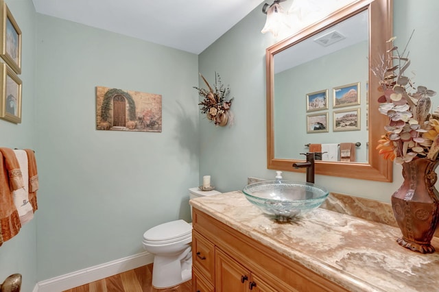 bathroom featuring vanity, toilet, and wood-type flooring