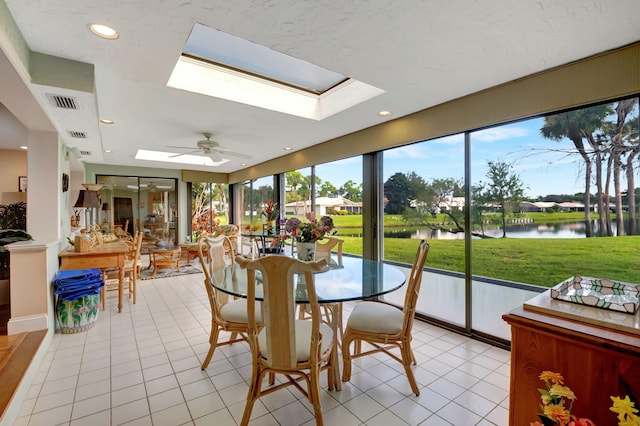 sunroom with a skylight, a water view, and ceiling fan