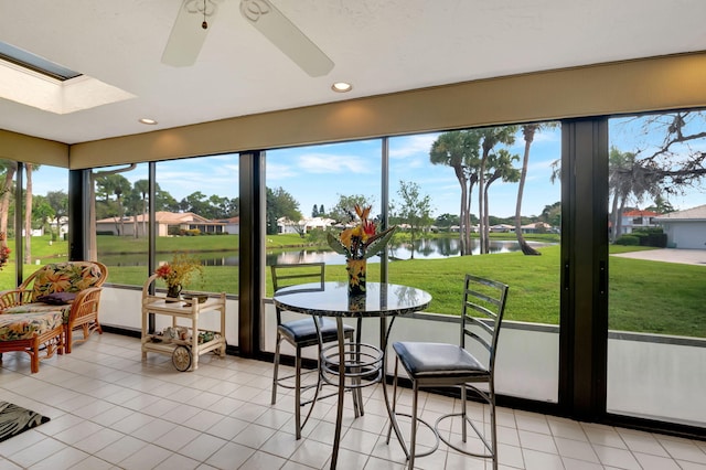 sunroom with a water view, a healthy amount of sunlight, and ceiling fan