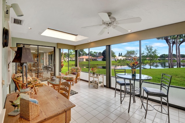 sunroom / solarium featuring a water view and ceiling fan