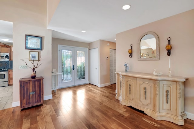 foyer entrance with light hardwood / wood-style flooring and french doors