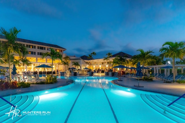 pool at dusk with a patio area